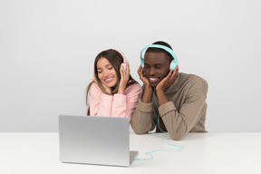 Atractiva pareja escuchando música en auriculares.
