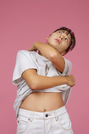Young woman with naked stomach looking up