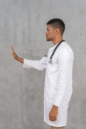 Vista lateral de um médico do sexo masculino mostrando a mão de parada