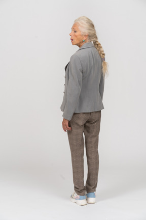 Rear view of an impressed old woman in grey jacket