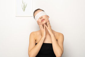 Femme avec un bandage oculaire tenant son visage