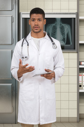 Puzzled doctor holding a tablet