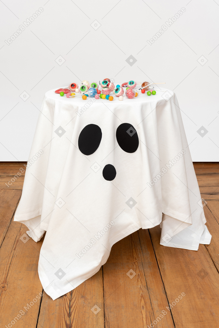 Candies lying on the white tablecloth with black eyes on it
