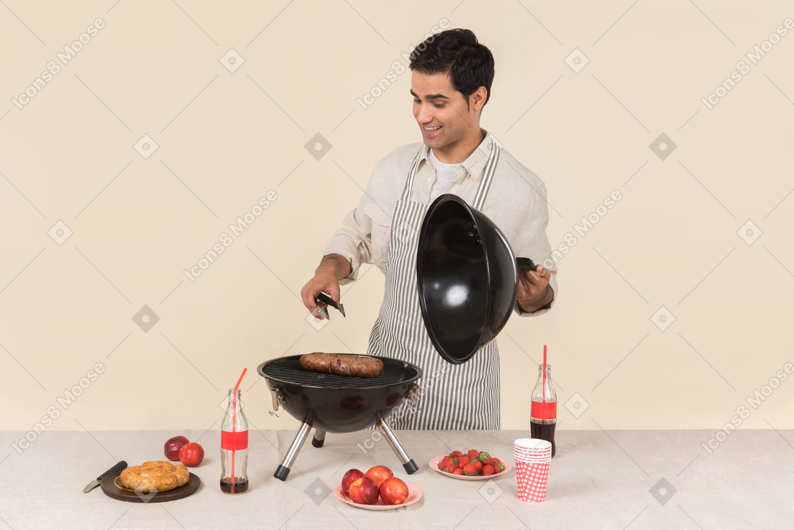 Giovane uomo caucasico sorridente che cucina bbq