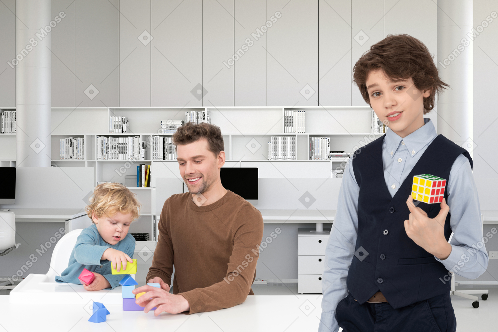 Papà e bambino che giocano con i mattoncini e fratello maggiore che tiene in mano il cubo di rubik