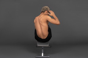 Vista posteriore di un uomo afro a torso nudo che fa crunch