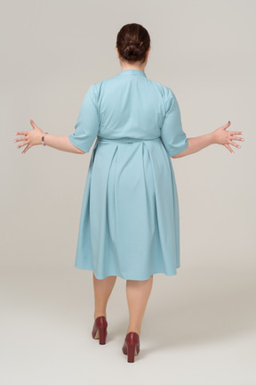一个穿着蓝色裙子的女人的后视图打手势