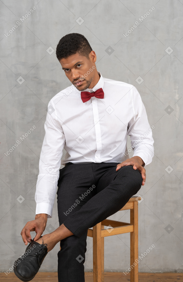 Young man on a chair adjusting his shoes