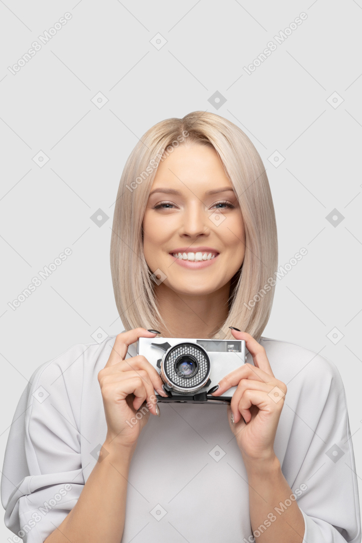 Mujer joven sosteniendo una cámara vintage