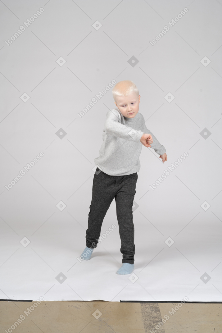 Vista frontal del niño con ropa informal dando vueltas