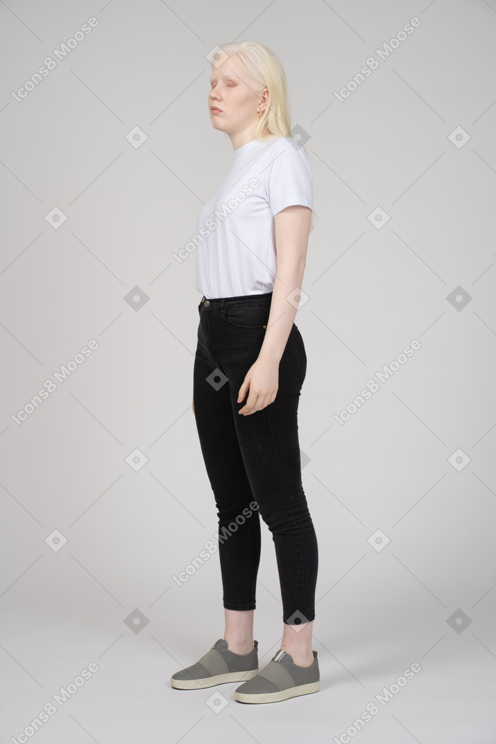 Vista di tre quarti di una giovane donna in abiti casual che distoglie lo sguardo