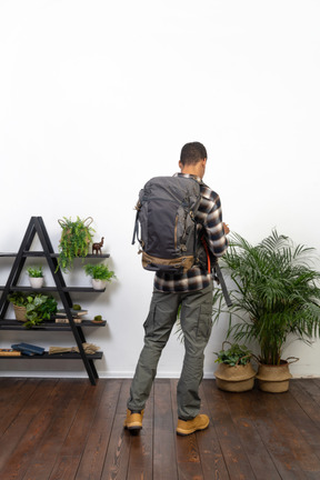 Three-quarter back view of a tourist with a backpack