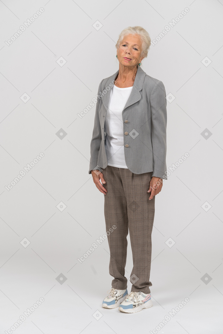 Front view of an old woman in suit looking at camera and making faces
