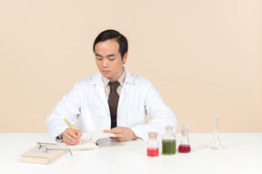 An asian scientist in a white coat working on a chemical experiment