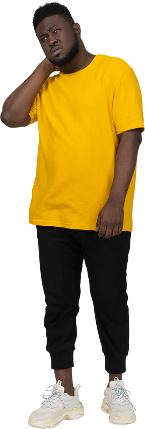 Vorderansicht eines dunkelhäutigen mannes in gelbem t-shirt, der seinen hals berührt