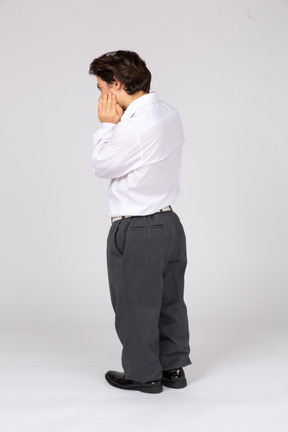 Back view of an office worker touching his cheek