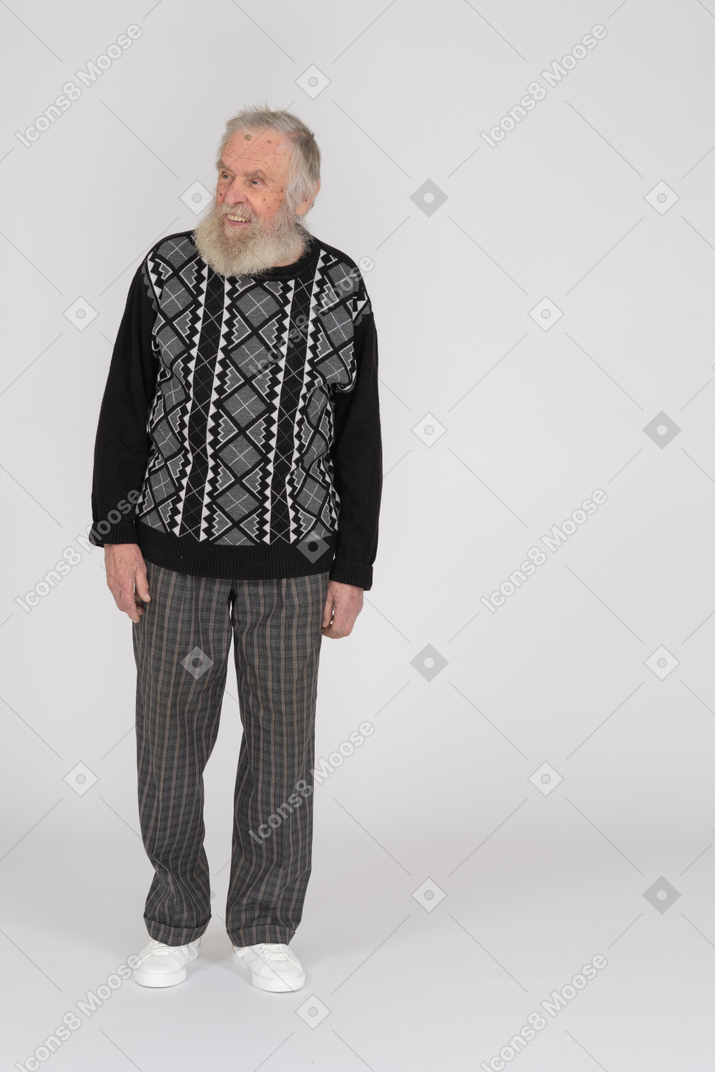 Smiling elderly man standing and looking aside