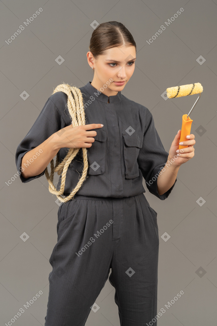 Woman in gray coveralls using a paint roller