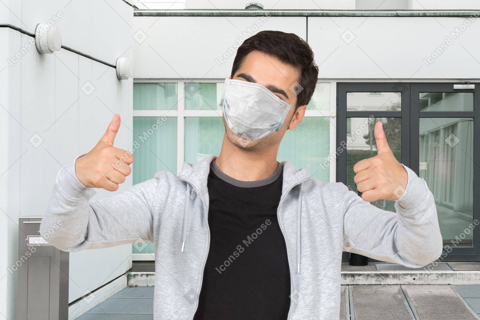 Homem com máscara médica mostrando polegares para cima