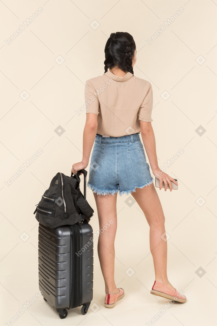 Back view of a young female traveler