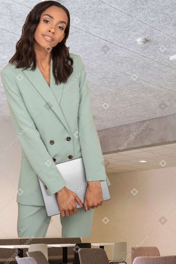 A woman in a green suit standing in a conference room
