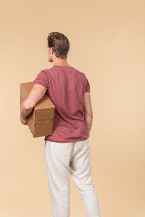 Delivery guy holding box and standing back to camera