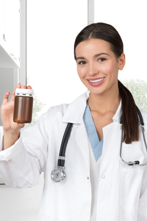 A female doctor holding a bottle of pills