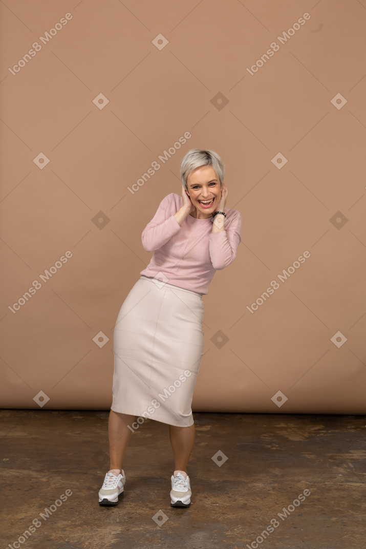 Vista frontal de uma mulher feliz em roupas casuais, olhando para a câmera