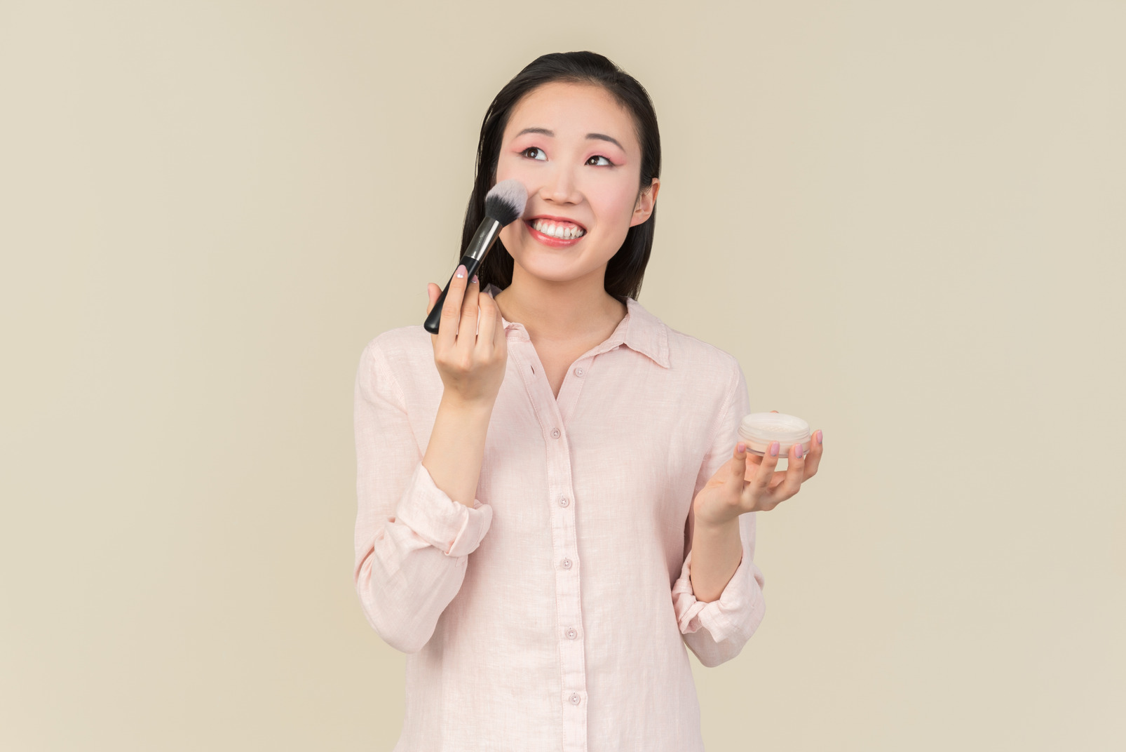 Young asian woman applying face powder