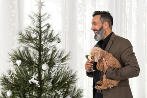 Stilvoller mann mit seinem hund, der weihnachten feiert