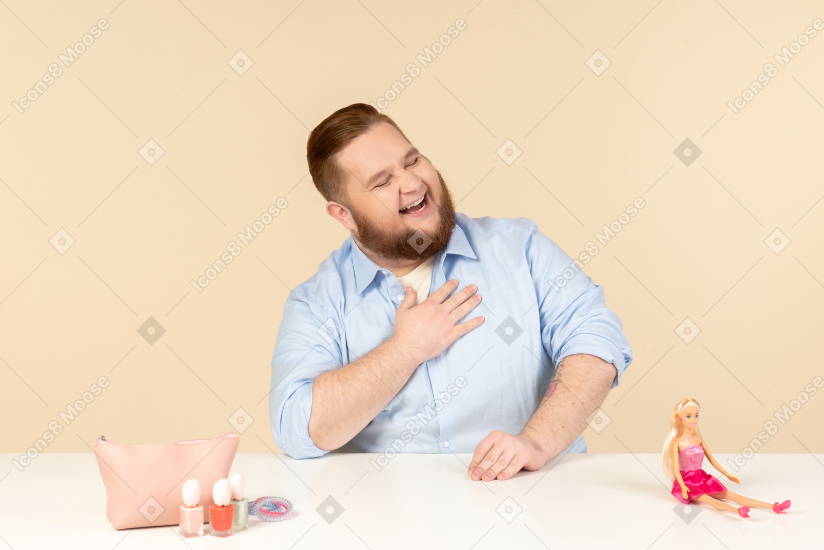 Laughing big man sitting at the table with cosmetics and barbie doll on it