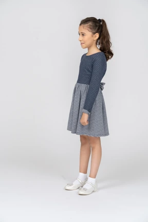 Three-quarter view of a girl smiling shyly