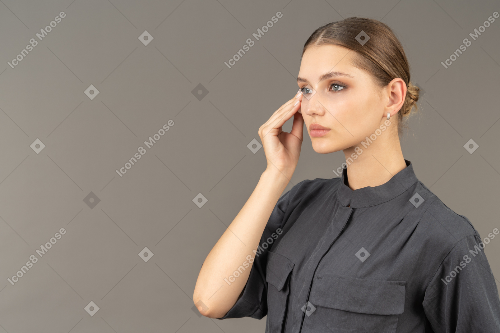 Вид в три четверти молодой женщины в комбинезоне, снимающей макияж с глаз