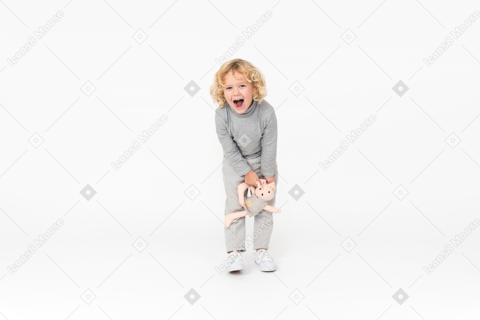 Смеющийся малыш мальчик держит игрушку