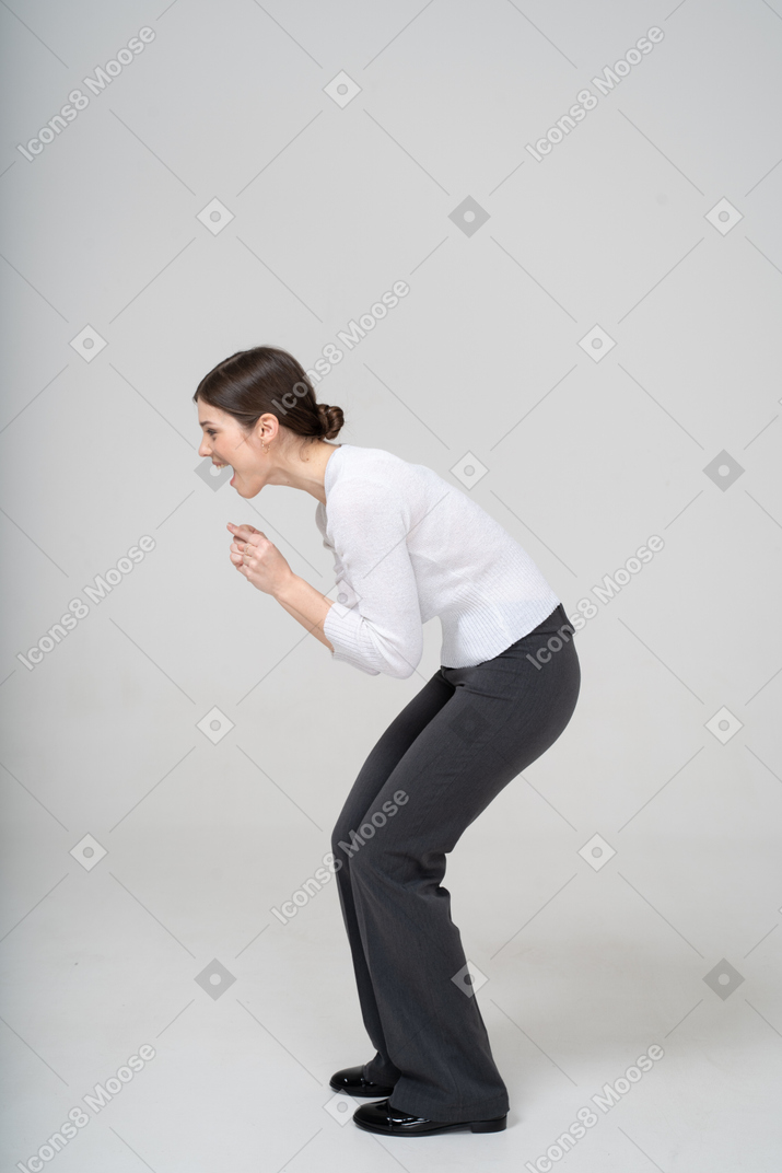 Side view of a happy woman in suit bending down
