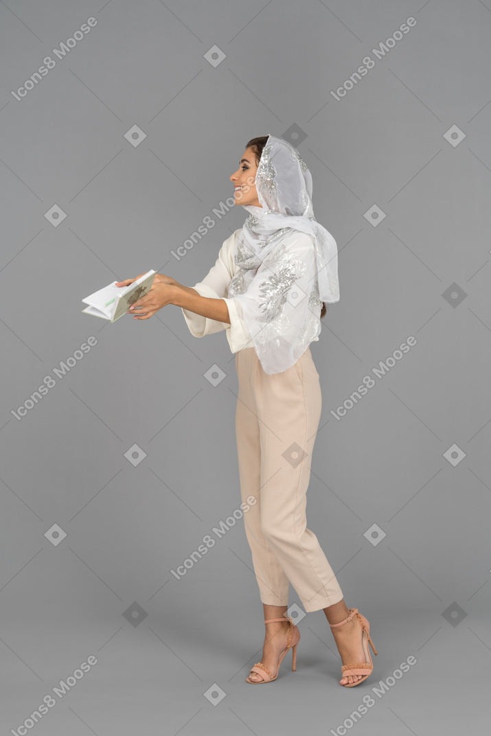 Delighted covered woman holding a notebook
