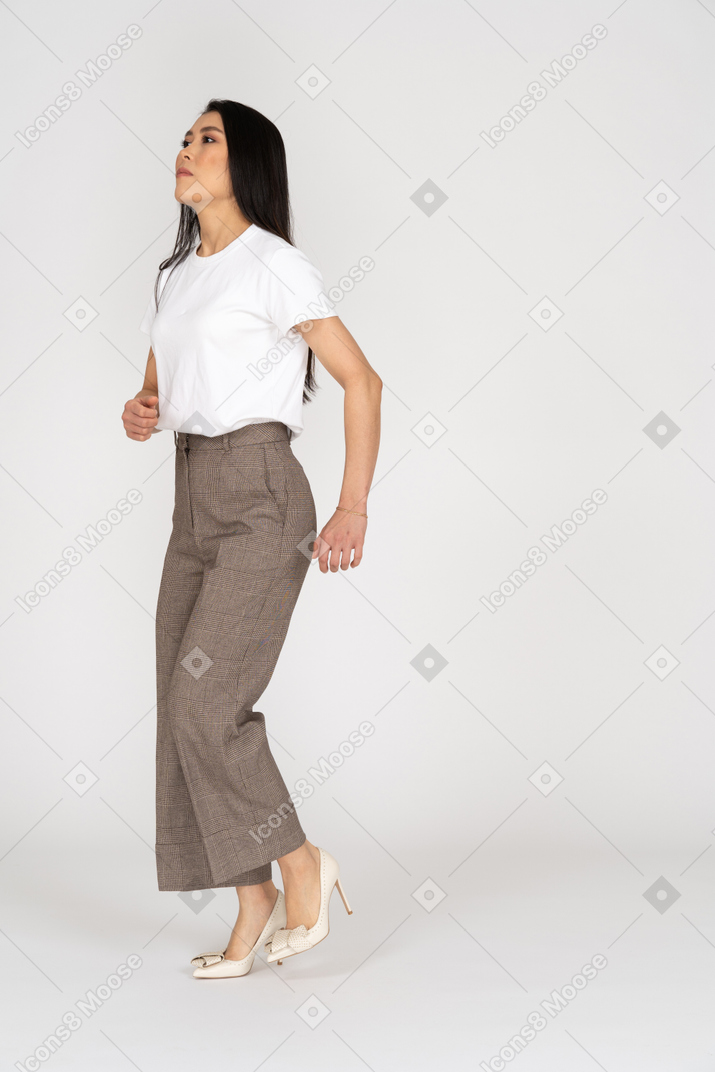 Three-quarter view of a running young lady in breeches and t-shirt