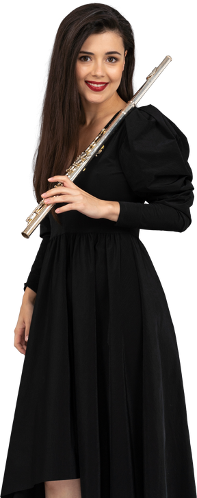 Vista frontale di una giovane donna sorridente in abito nero tenendo il flauto