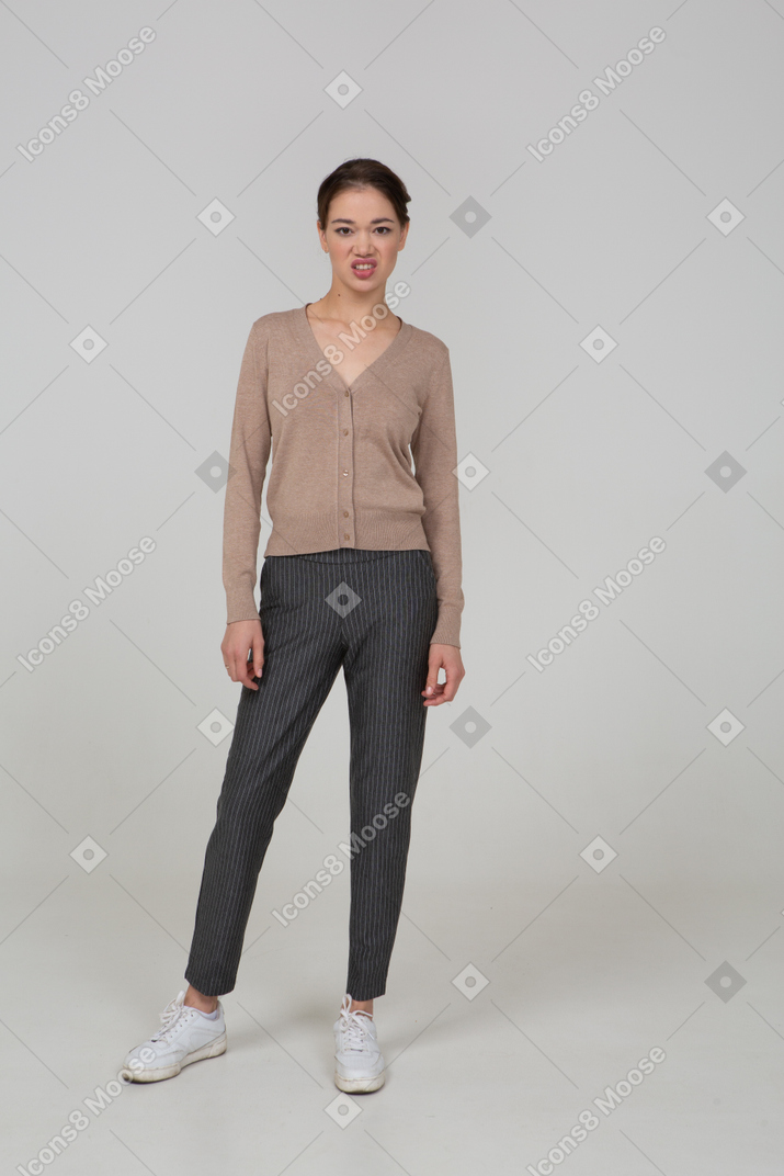 Front view of a grimacing lady in pullover and pants looking aside