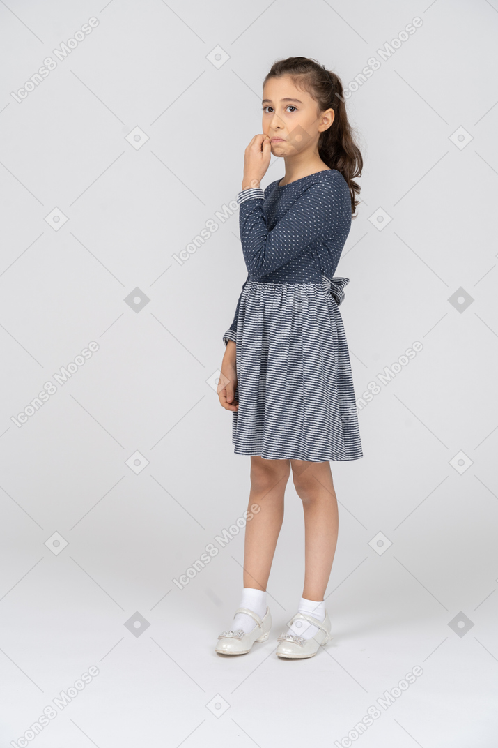 Three-quarter view of a girl doing a sewing mouth gesture