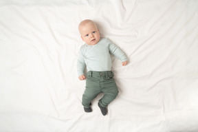 Baby boy lying and looking carefully into camera