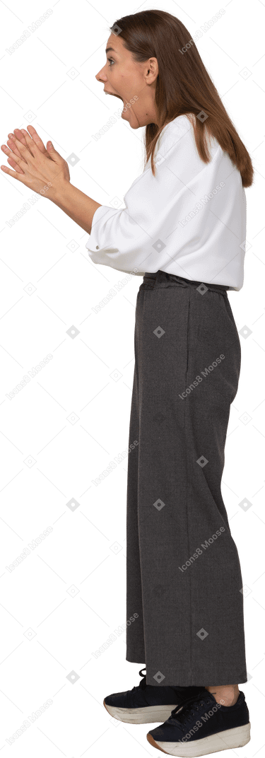 Side view of an excited young lady in office clothing raising hands