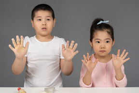 Bruder und schwester posieren mit erhobenen händen