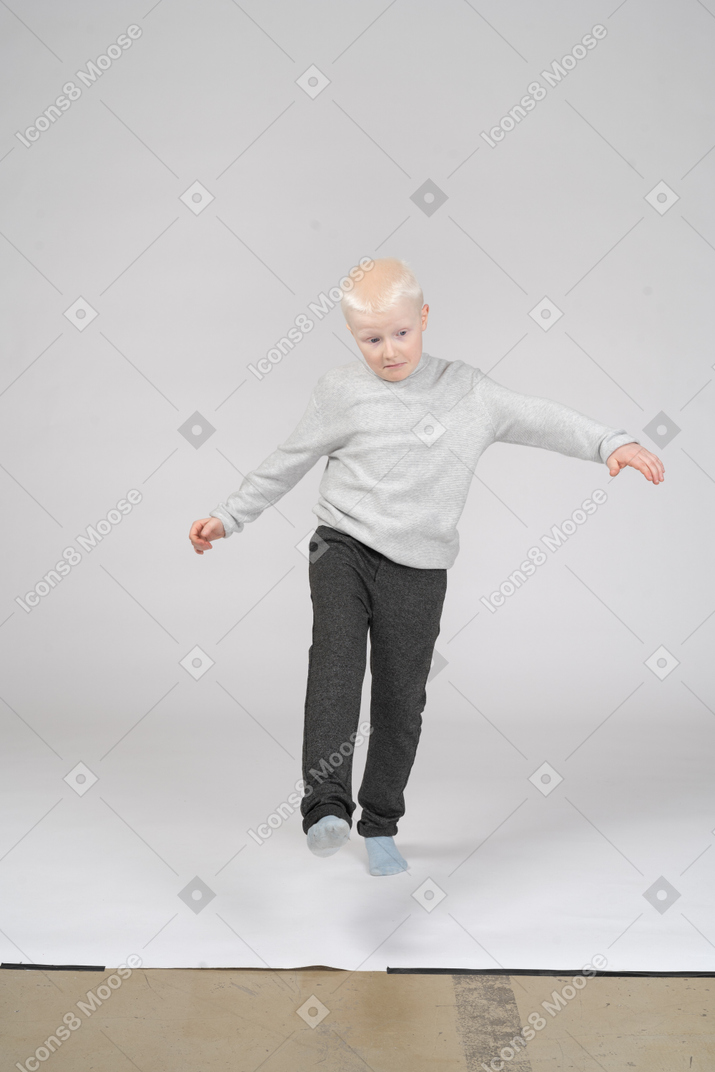 Front view of boy in casual clothes walking towards camera