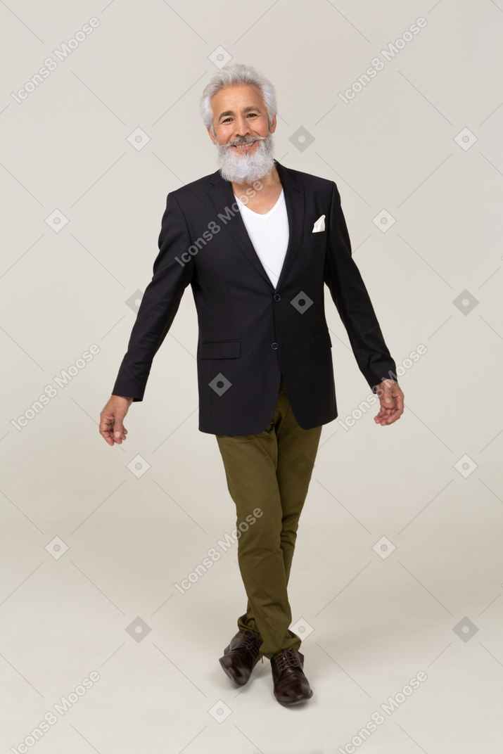 Hombre sonriente con una chaqueta caminando