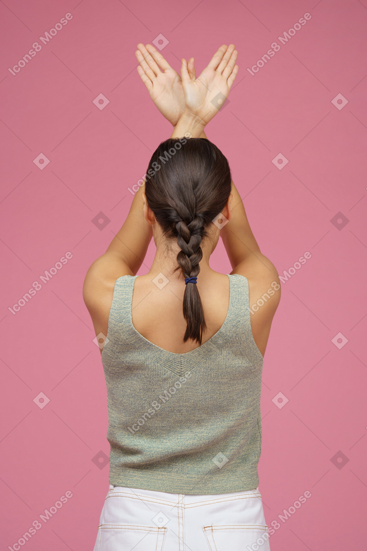 双手交叉在头顶的年轻女子的背部
