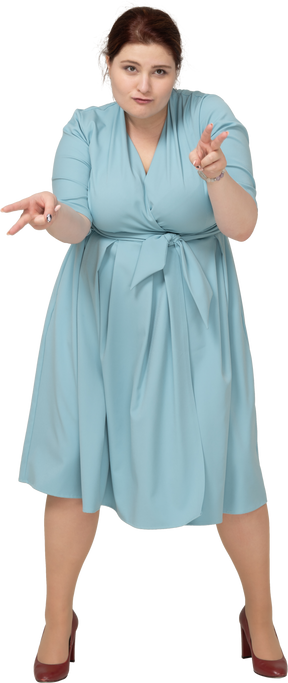 V記号を示す青いドレスを着た女性の正面図