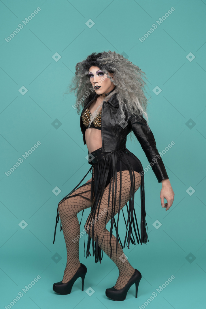 Drag queen in all black outfit half squatting