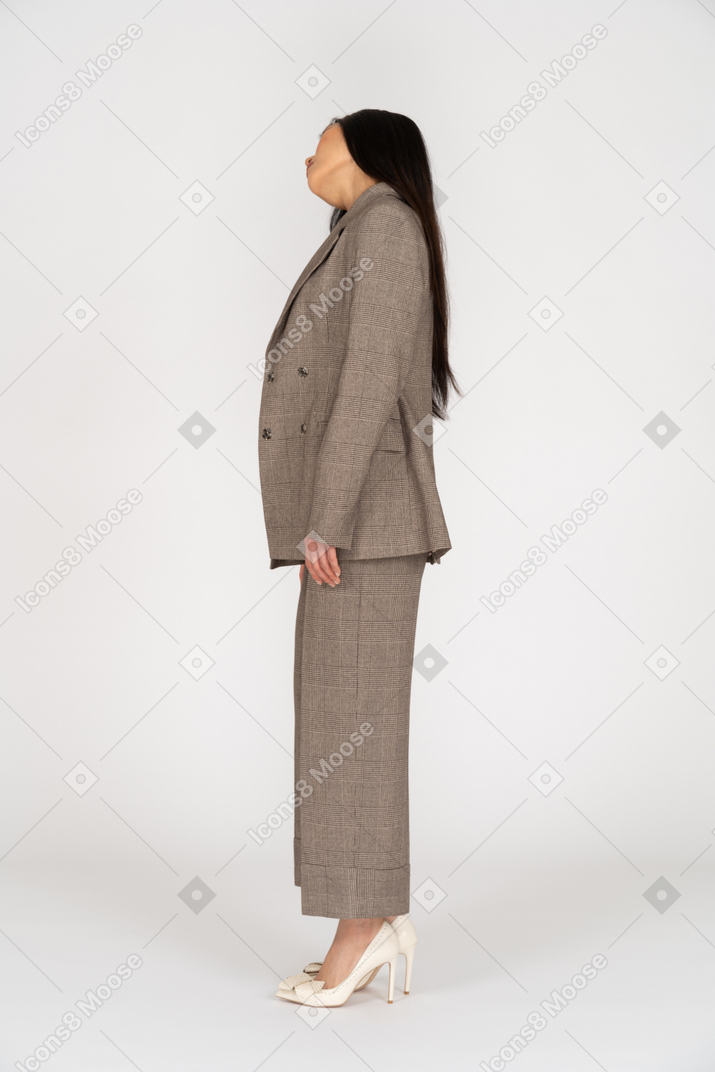 頭を傾ける茶色のビジネススーツの若い女性の側面図
