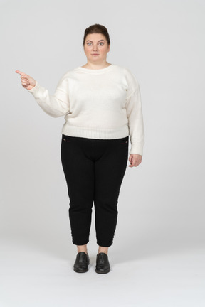Plump woman in casual clothes pointing with a finger